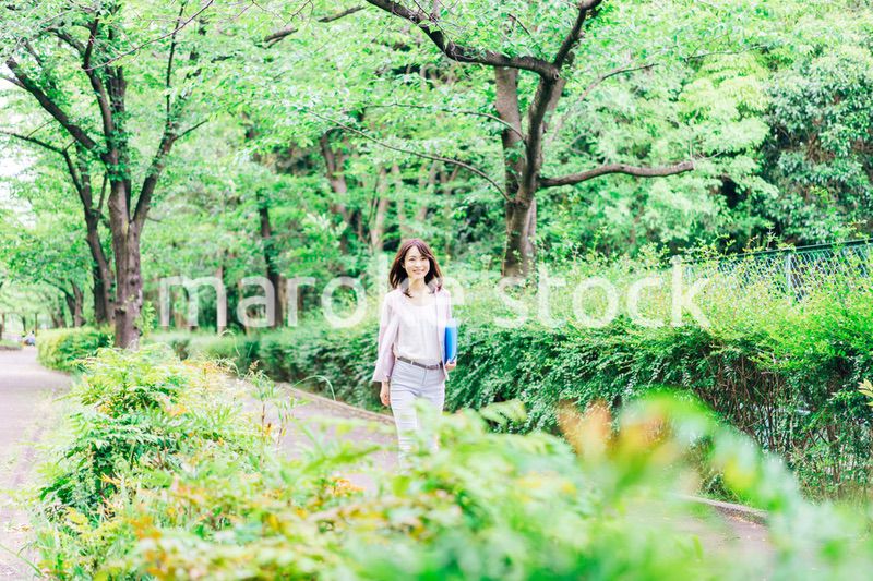 書類を持って歩く若いビジネスウーマン