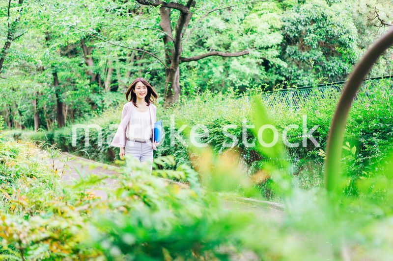 書類を持って歩く若いビジネスウーマン
