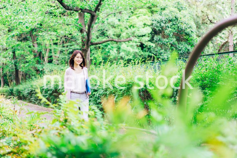 書類を持って歩く若いビジネスウーマン