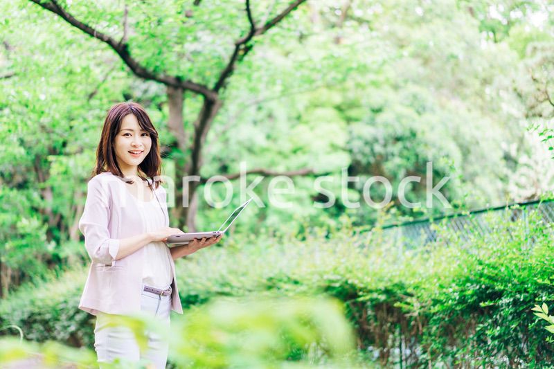 外でパソコンを使う若いビジネスウーマン