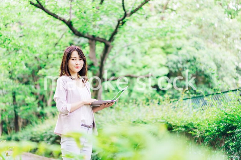 外でパソコンを使う若いビジネスウーマン