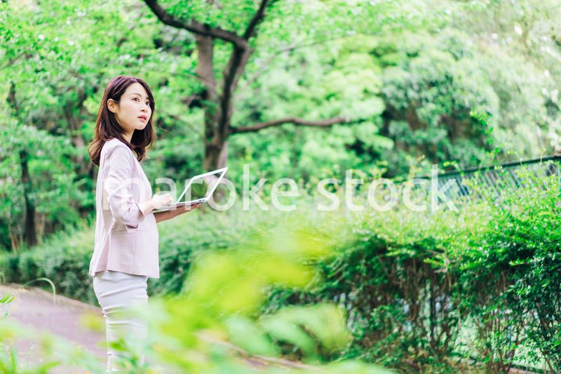 外でパソコンを使う若いビジネスウーマン