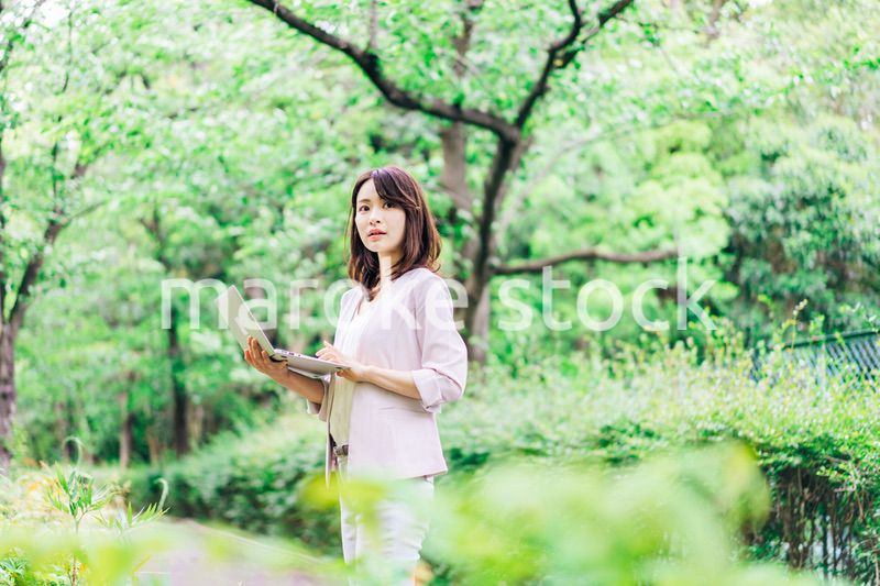 外でパソコンを使う若いビジネスウーマン