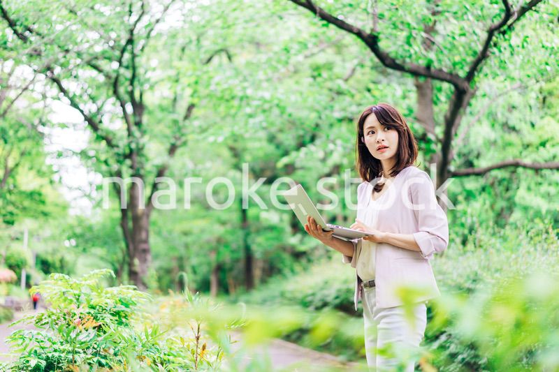 外でパソコンを使う若いビジネスウーマン