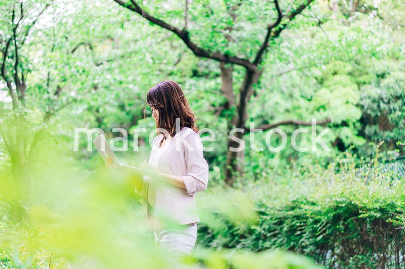 外でパソコンを使う若いビジネスウーマン