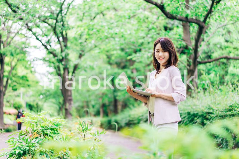 外でパソコンを使う若いビジネスウーマン