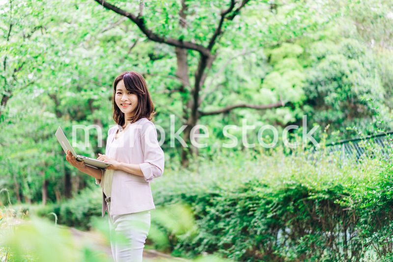 外でパソコンを使う若いビジネスウーマン