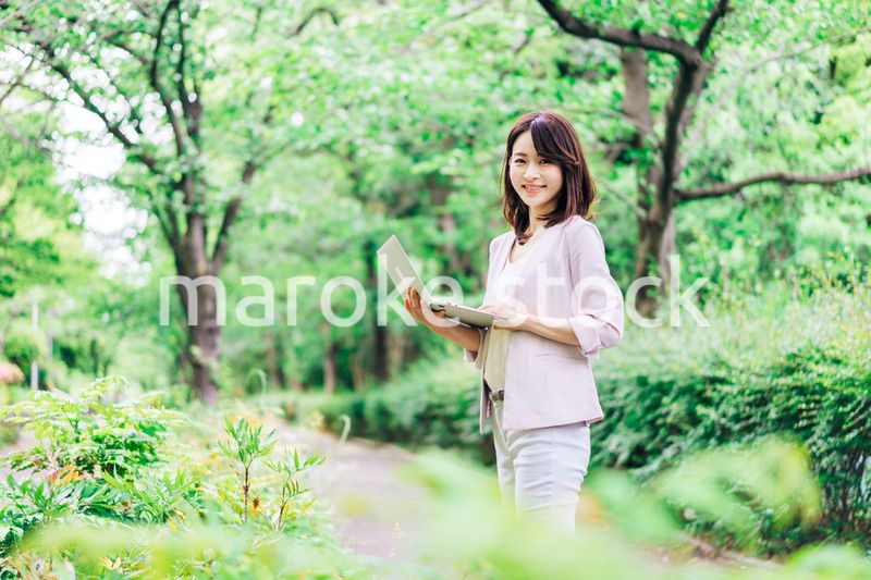 外でパソコンを使う若いビジネスウーマン