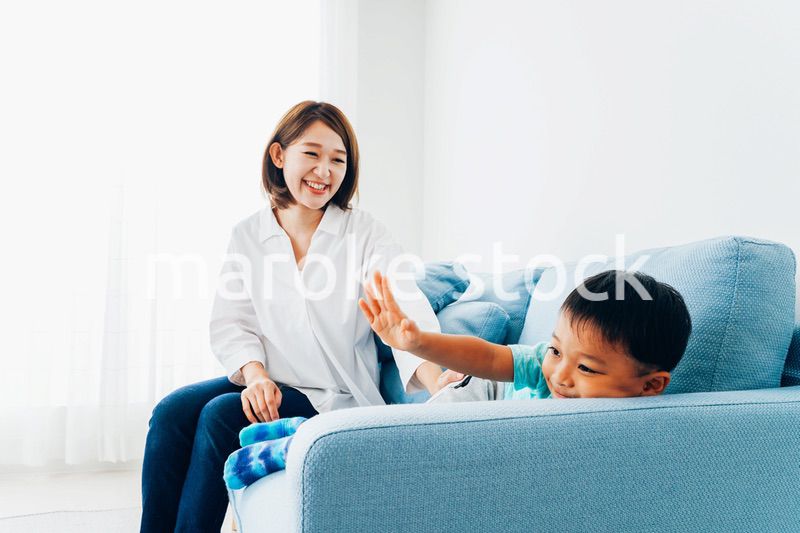 家でお母さんと遊ぶ小さな男の子