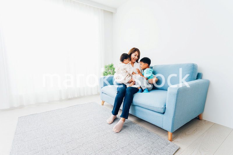 家で子どもたちと遊ぶ若い主婦