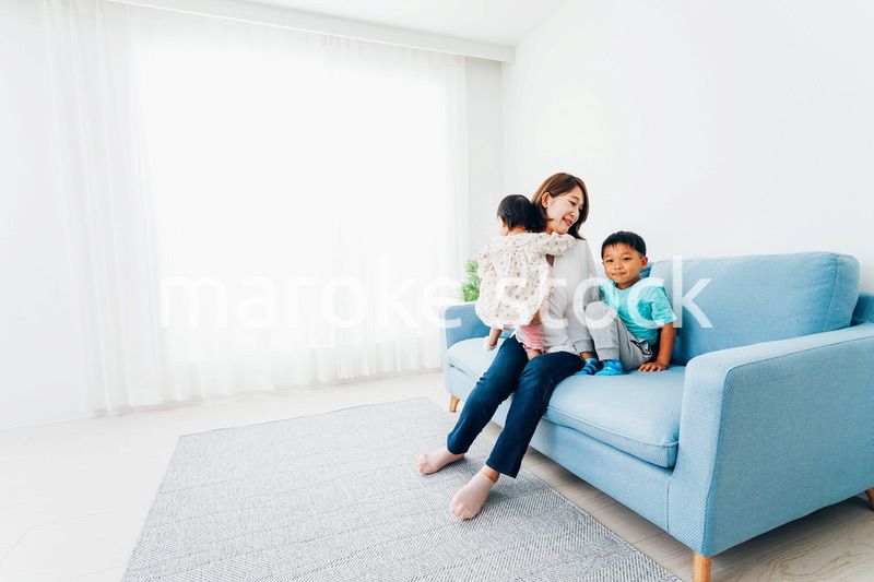 家で子どもたちと遊ぶ若い主婦