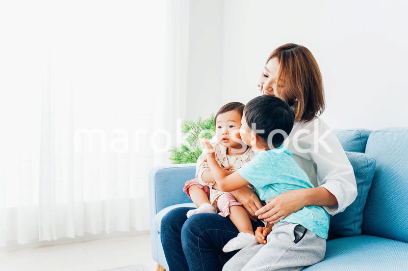 家で子どもたちと遊ぶ若い主婦