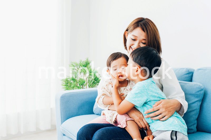 家で子どもたちと遊ぶ若い主婦