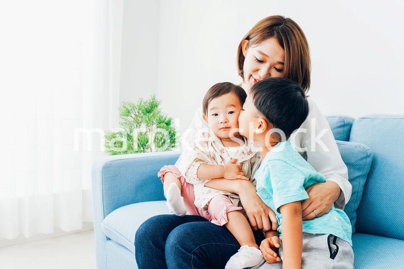 家で子どもたちと遊ぶ若い主婦