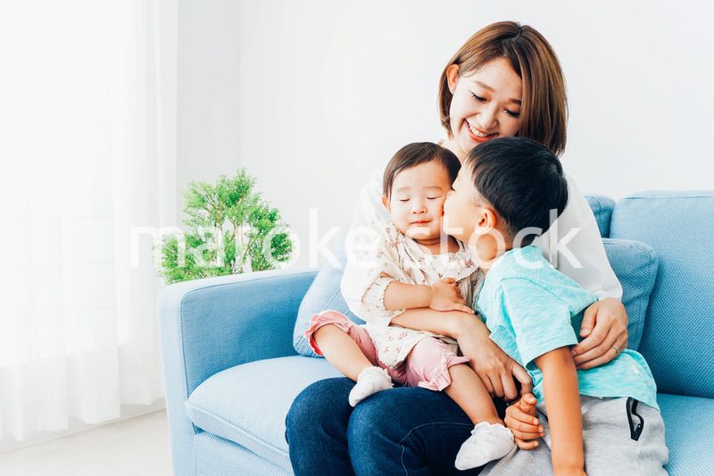 家で子どもたちと遊ぶ若い主婦