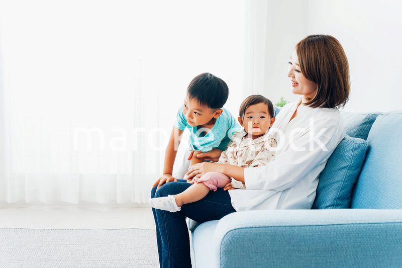 家で子どもたちと遊ぶ若い主婦