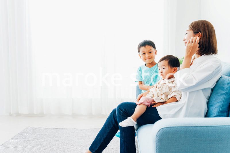 家で子どもたちと遊ぶ若い主婦