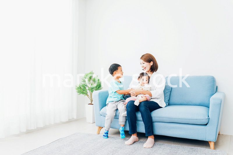 家で子どもたちと遊ぶ若い主婦