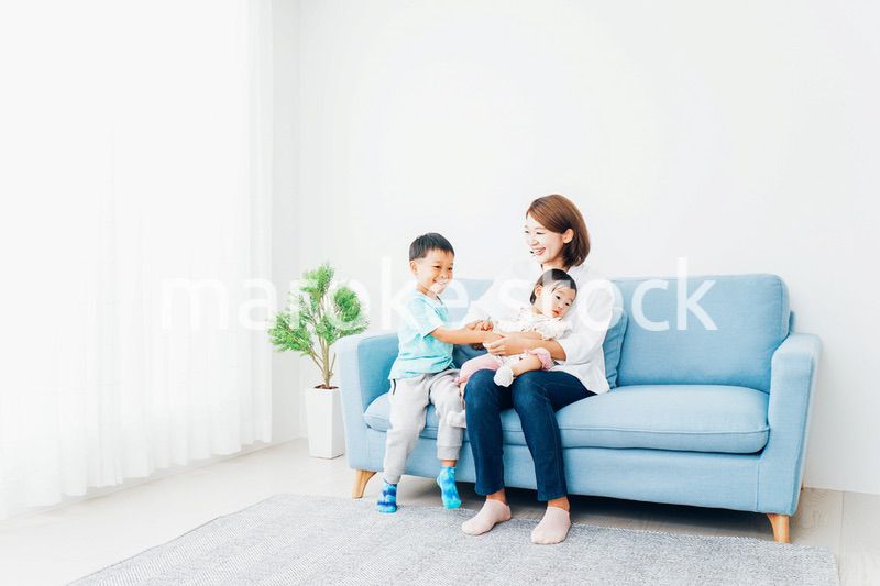 家で子どもたちと遊ぶ若い主婦