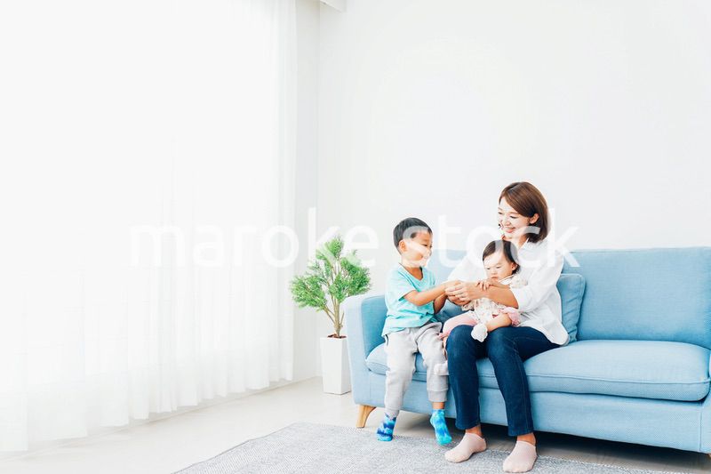 家で子どもたちと遊ぶ若い主婦