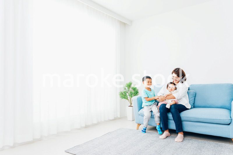 家で子どもたちと遊ぶ若い主婦