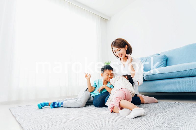 家で子どもたちと遊ぶ若い主婦