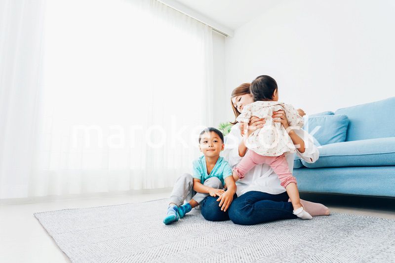 家で子どもたちと遊ぶ若い主婦