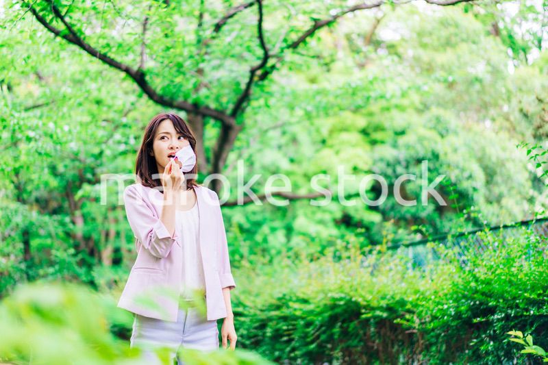 マスクで息苦しさを感じる若いビジネスウーマン