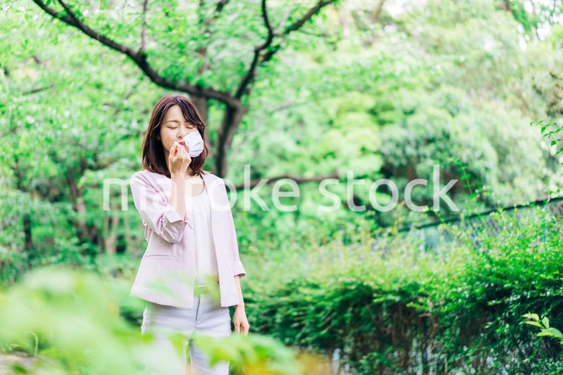 マスクで息苦しさを感じる若いビジネスウーマン