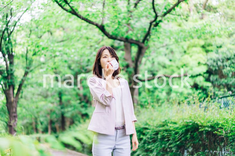 マスクで息苦しさを感じる若いビジネスウーマン