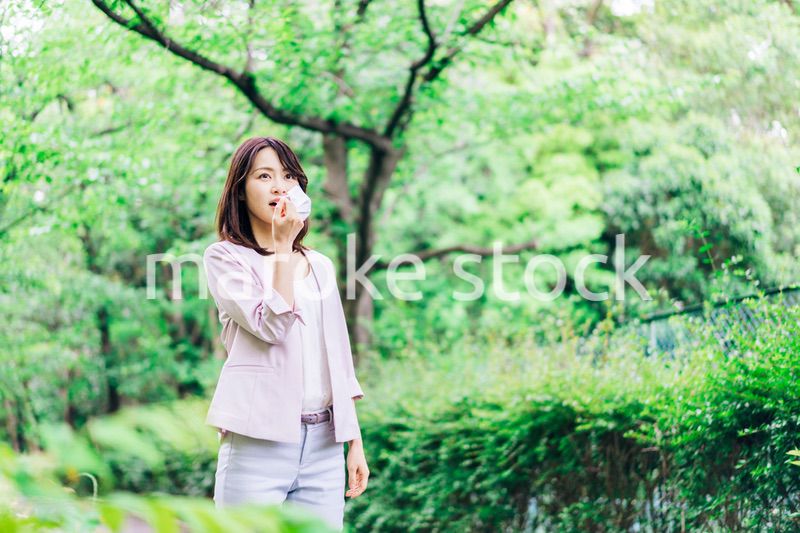 マスクで息苦しさを感じる若いビジネスウーマン