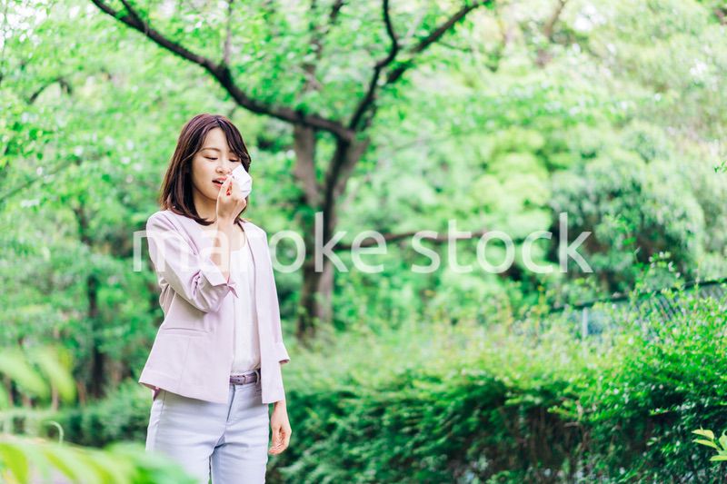 マスクで息苦しさを感じる若いビジネスウーマン