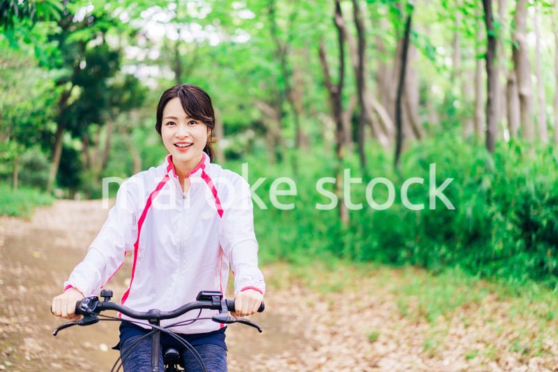 自然の中でサイクリングを楽しむ若い女性