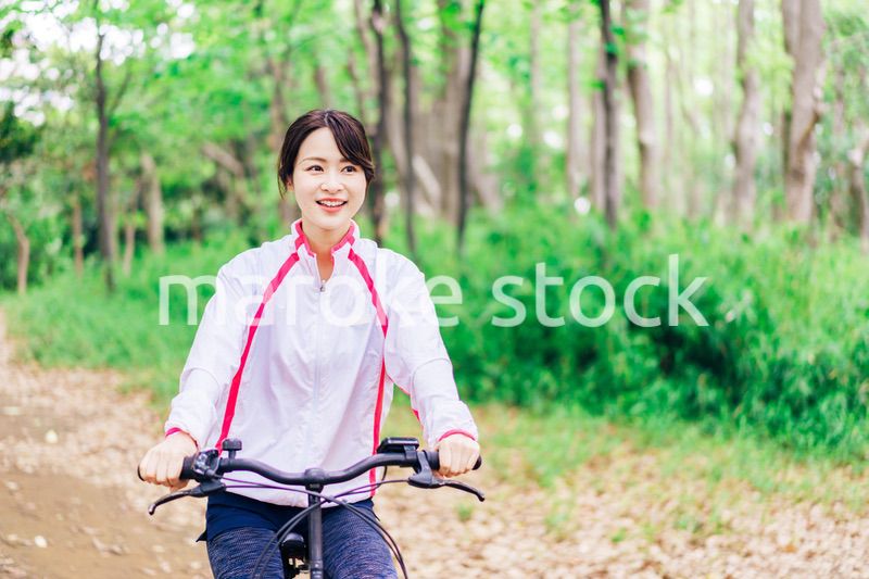 自然の中でサイクリングを楽しむ若い女性