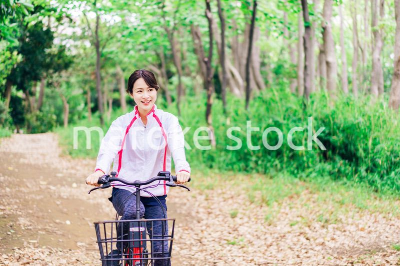 自然の中でサイクリングを楽しむ若い女性