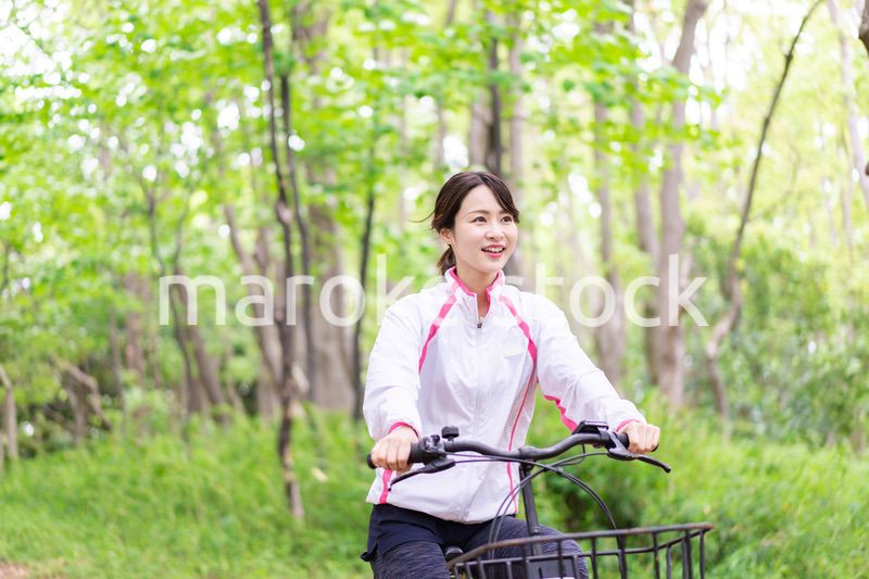 自然の中でサイクリングを楽しむ若い女性