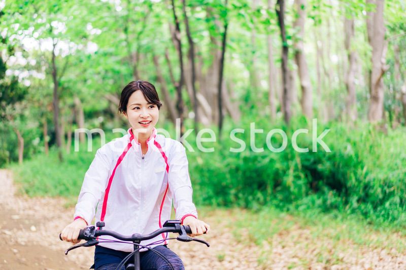 自然の中でサイクリングを楽しむ若い女性