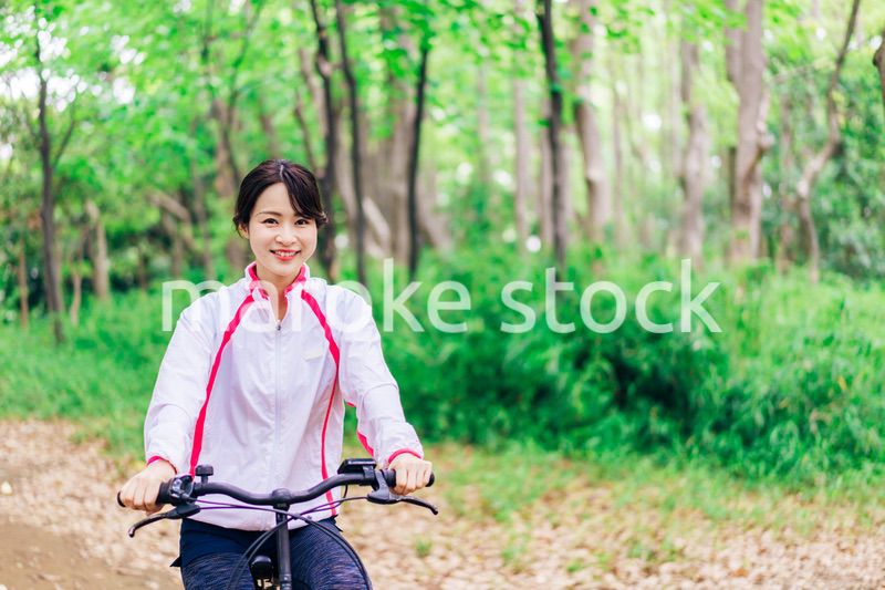 自然の中でサイクリングを楽しむ若い女性