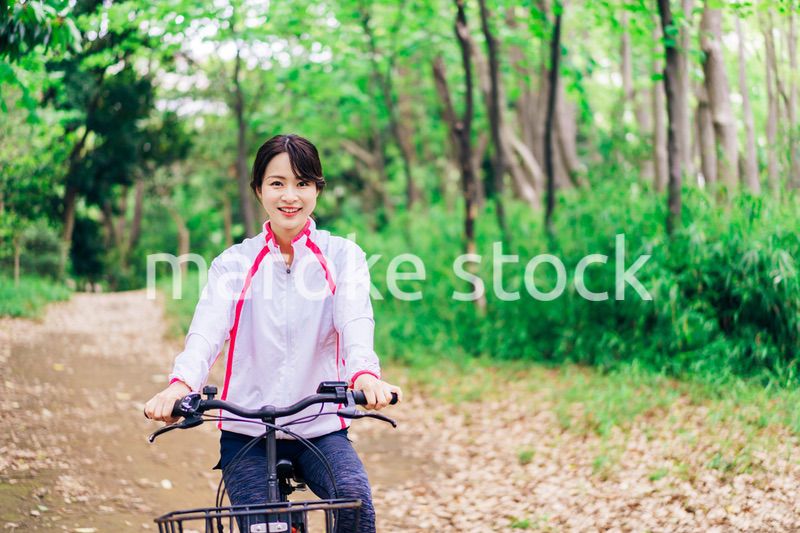 自然の中でサイクリングを楽しむ若い女性