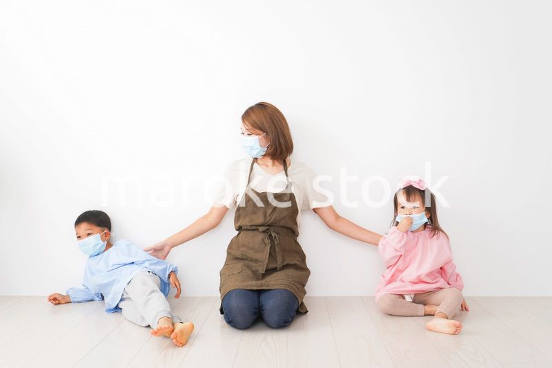 ソーシャルディスタンスを確保する保育士と子ども