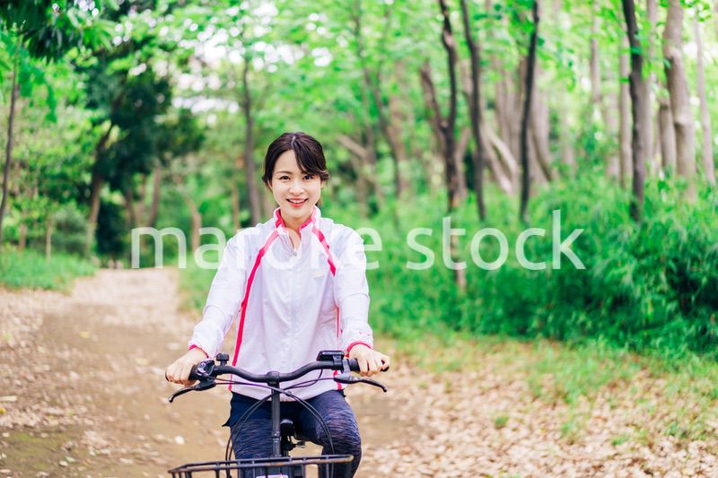 自然の中でサイクリングを楽しむ若い女性