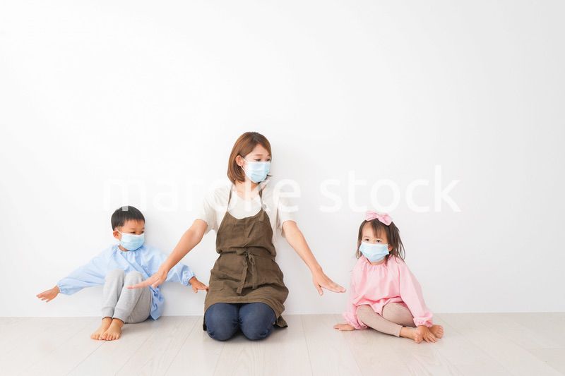 ソーシャルディスタンスを確保する保育士と子ども