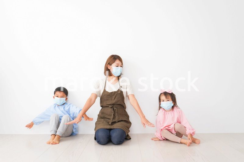 ソーシャルディスタンスを確保する保育士と子ども