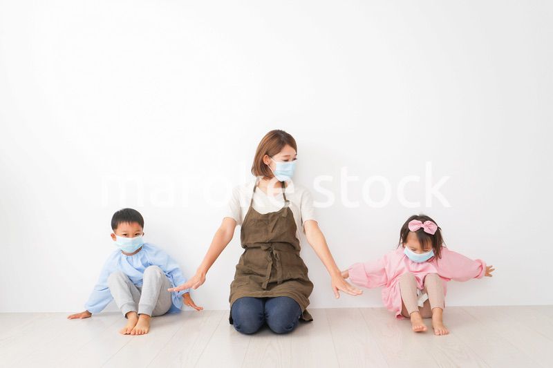 ソーシャルディスタンスを確保する保育士と子ども