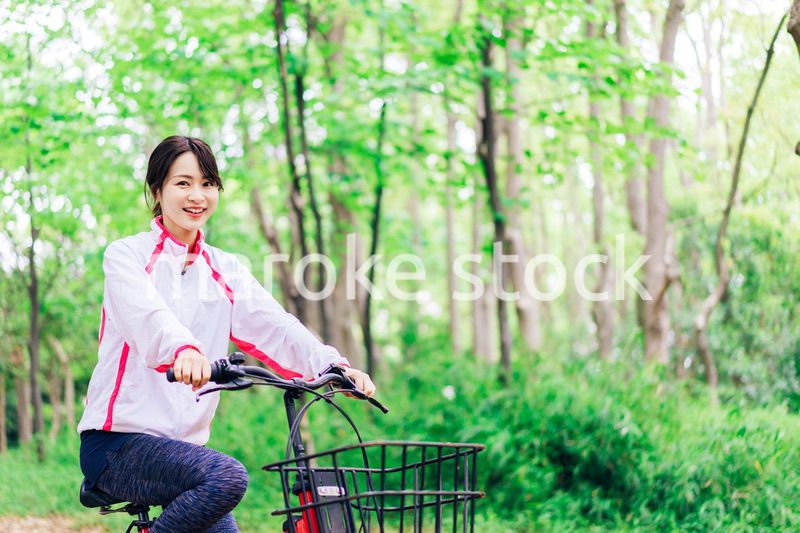 自然の中でサイクリングを楽しむ若い女性