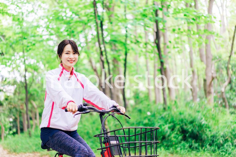 自然の中でサイクリングを楽しむ若い女性