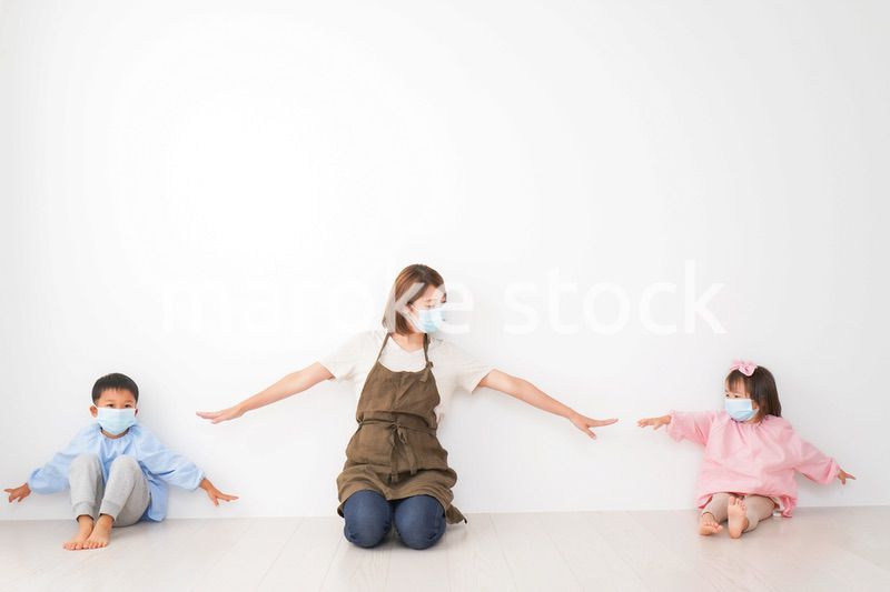 ソーシャルディスタンスを確保する保育士と子ども