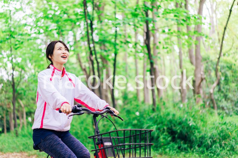 自然の中でサイクリングを楽しむ若い女性