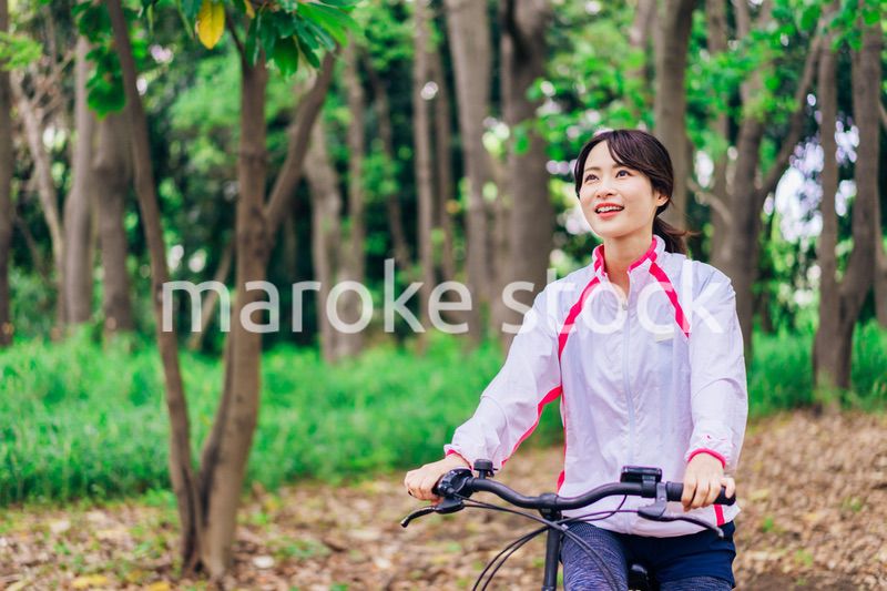 自然の中でサイクリングを楽しむ若い女性