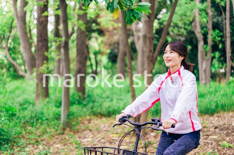自然の中でサイクリングを楽しむ若い女性